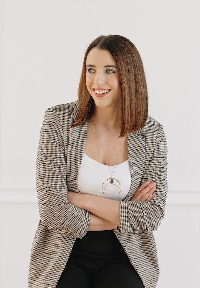 Portrait of Emily Sledge, LCSW, arms crossed, smiling warmly
