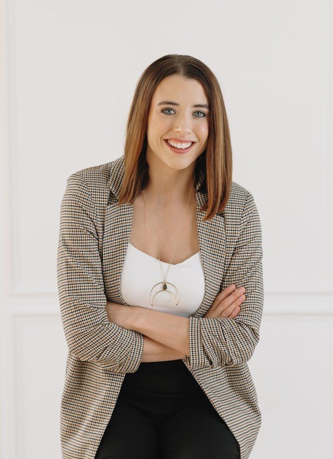Emily Sledge, LCSW, smiling warmly with arms crossed